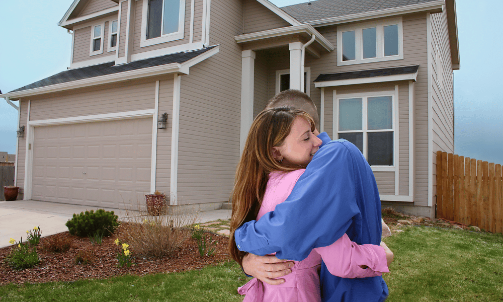 New homeowners embracing outside of their house